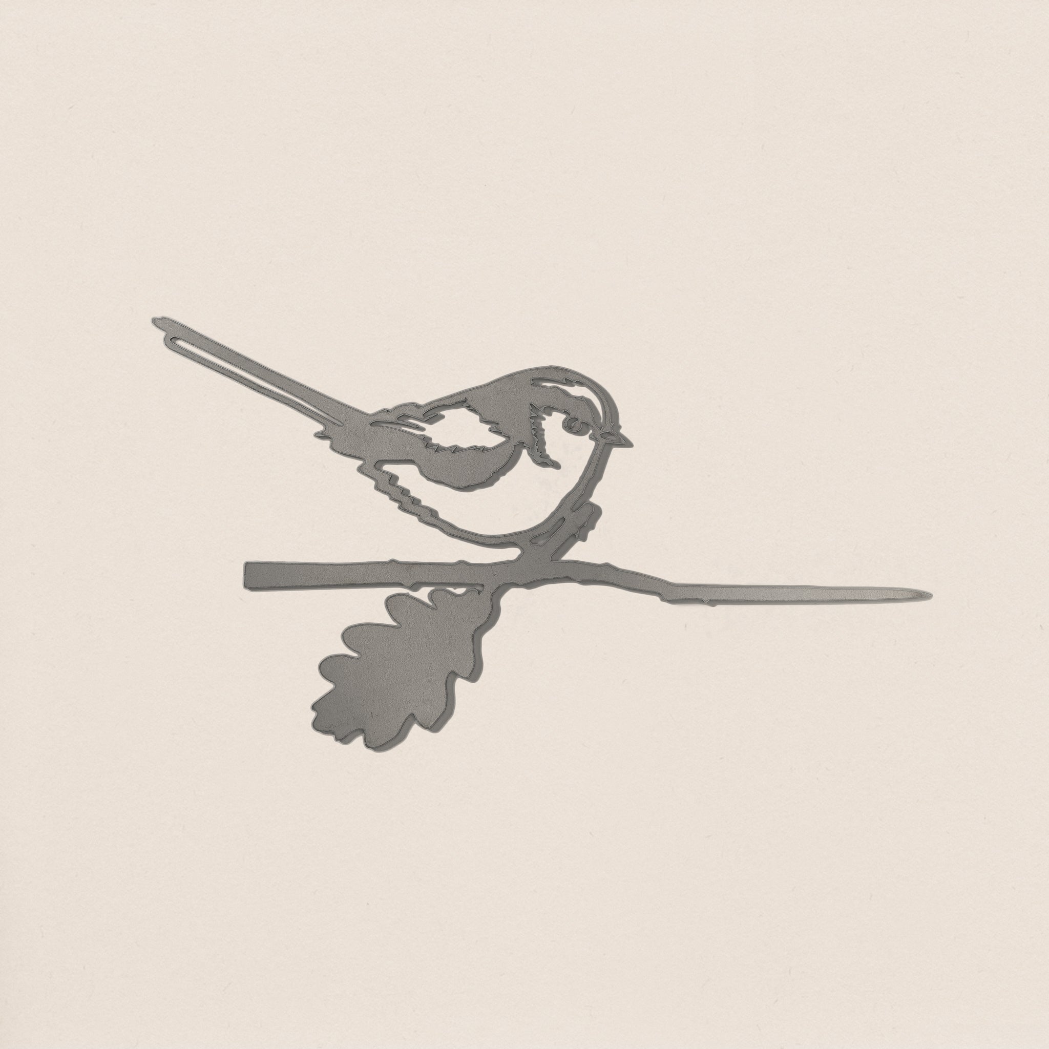 The Metalbird UK Long-tailed Tit is a sleek gray corten steel silhouette of a small bird perched on a branch with an oak leaf—ideal as unique yard art or a thoughtful gift.
