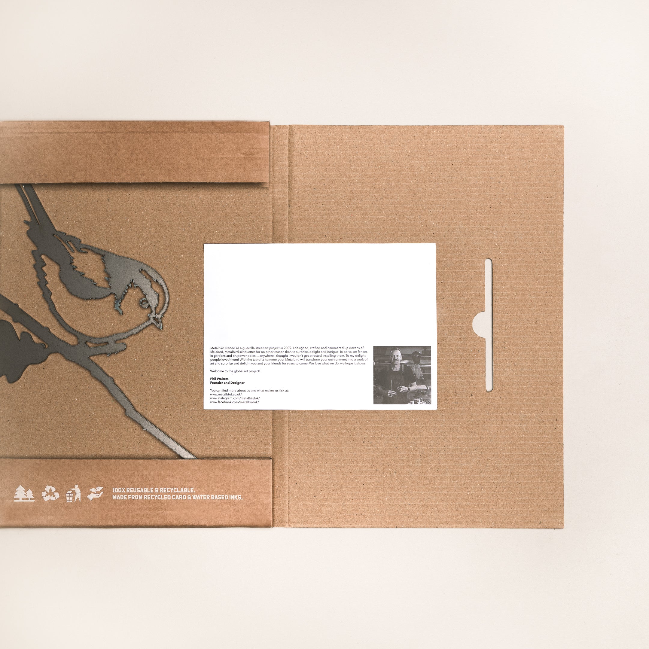 The Long-tailed Tit folder by Metalbird UK features a bird silhouette on brown cardboard, a white card with text and photo on the right, and eco-friendly symbols at the bottom left—perfect for thoughtful gifting.