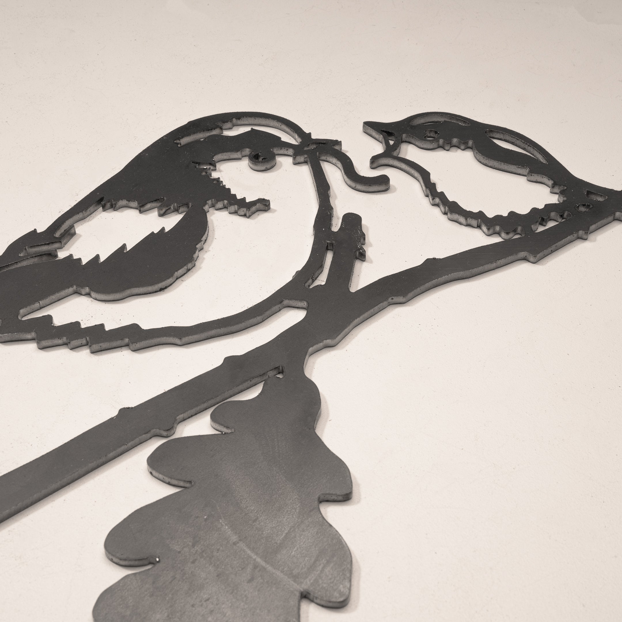 The Long-tailed Tit & Chick by Metalbird UK is a corten steel wall art featuring two birds on an oak branch in silhouette, set against a plain light background.
