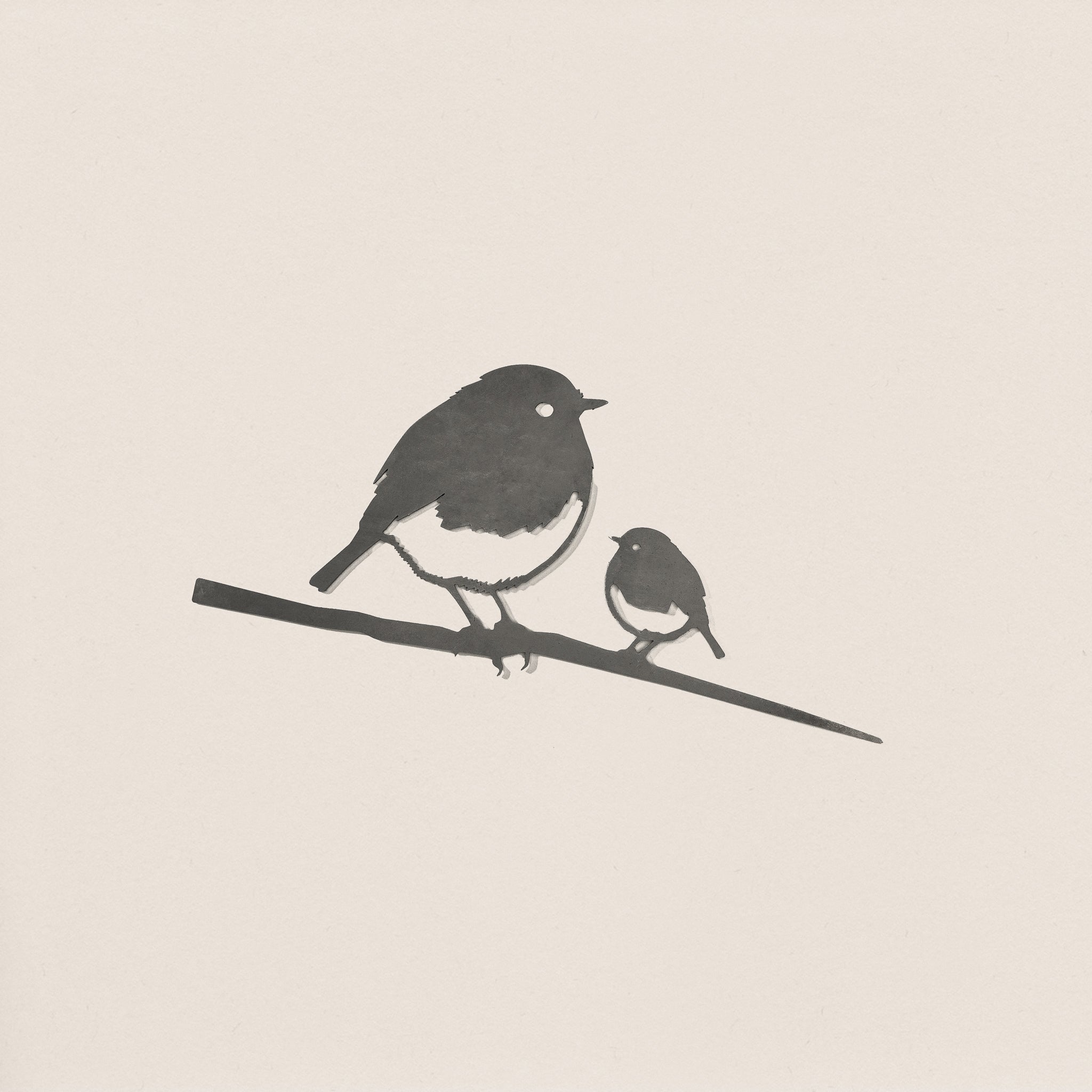 Robin and Chick by Metalbird UK features a minimalist silhouette of a large robin and its chick perched on a branch against a light background—ideal as a gift or delightful garden art.