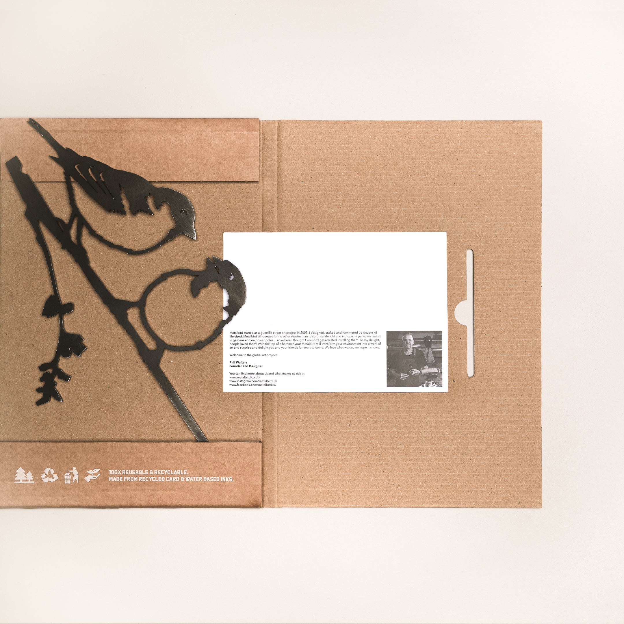 The "Pair of Sparrows" by Metalbird UK is a brown cardboard folder featuring black silhouettes of two birds on a branch. Recycling symbols appear on the folder, and inside, a white card with text and a photo can be seen.