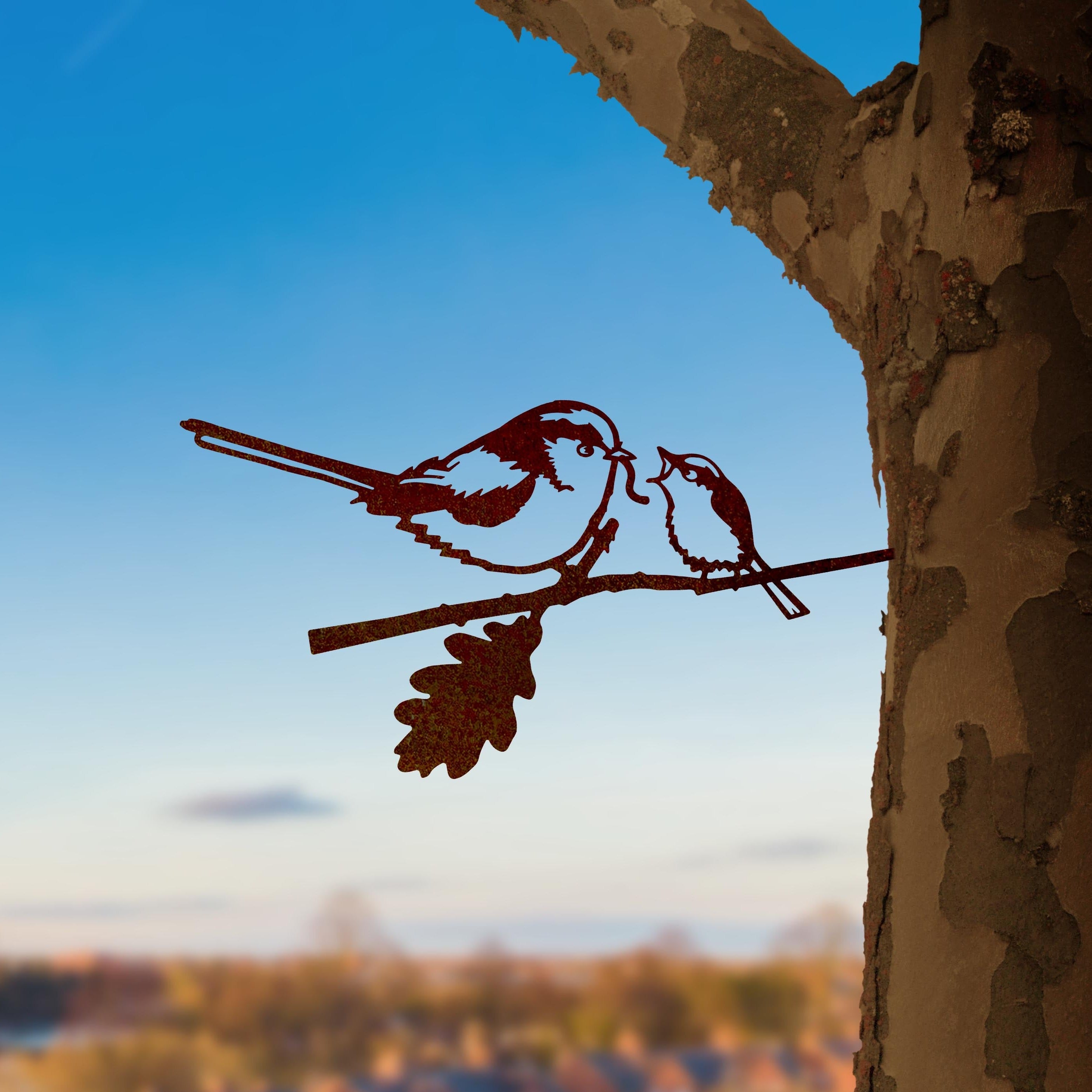 The Long-tailed Tit & Chick by Metalbird UK is a charming metal silhouette of two birds on a branch, designed for mounting on trees—a unique garden art piece and a perfect gift for nature lovers.