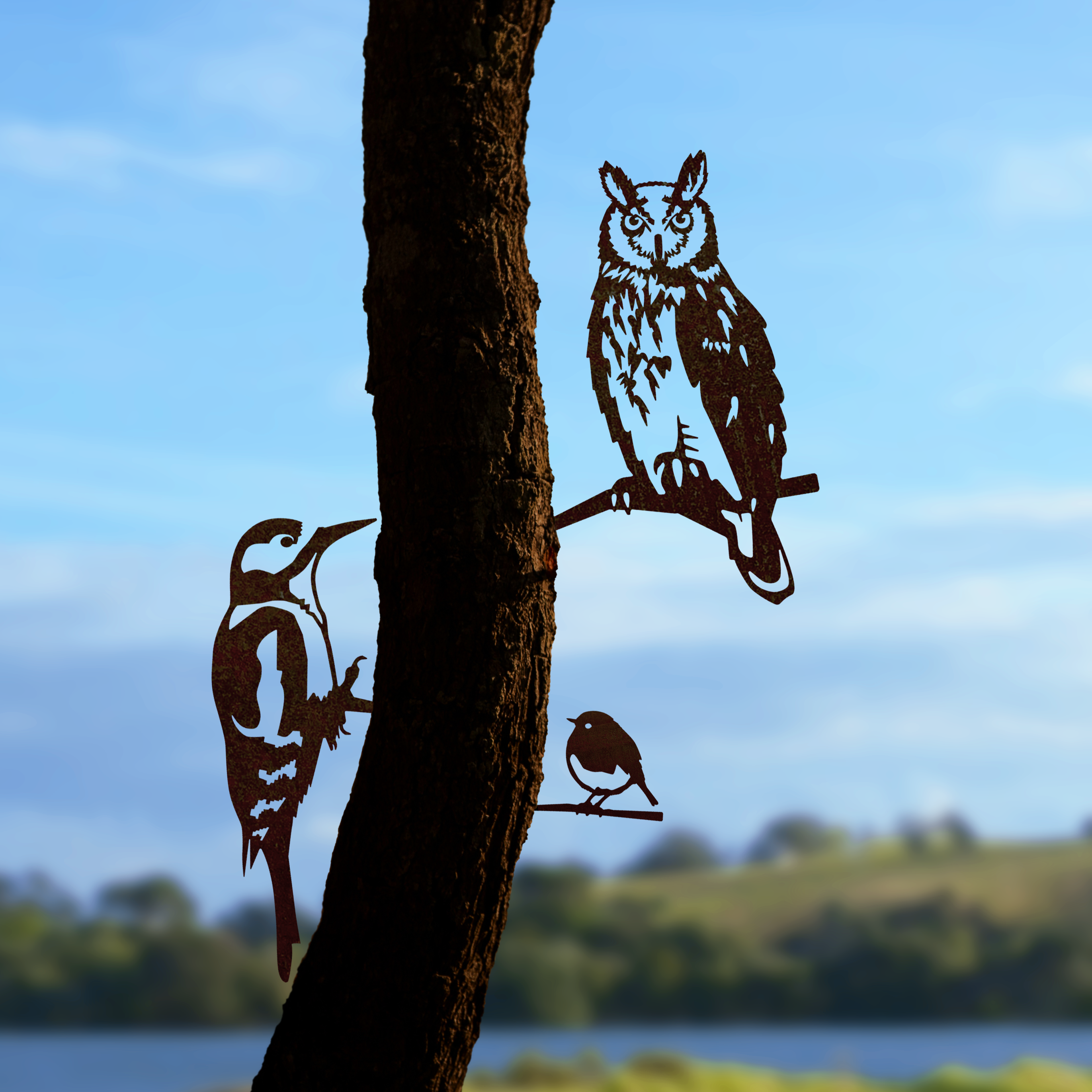 Metalbird UK's FLOCK FAVOURITES features laser-cut metal silhouettes of a woodpecker, owl, and small bird for striking garden art on any tree—an ideal gift for nature lovers.