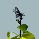 The Metalbird UK Honey Bee Single Plant Stake (70cm) features a premium black metal bee silhouette nestled among green leaves, set against a simple gray backdrop.