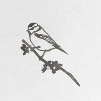 A simple, black stencil-style "Blue Tit - Seconds" by Metalbird UK, depicting a bird perched on a leafy branch—ideal as inspiration for corten steel yard art—set against a plain white textured background.