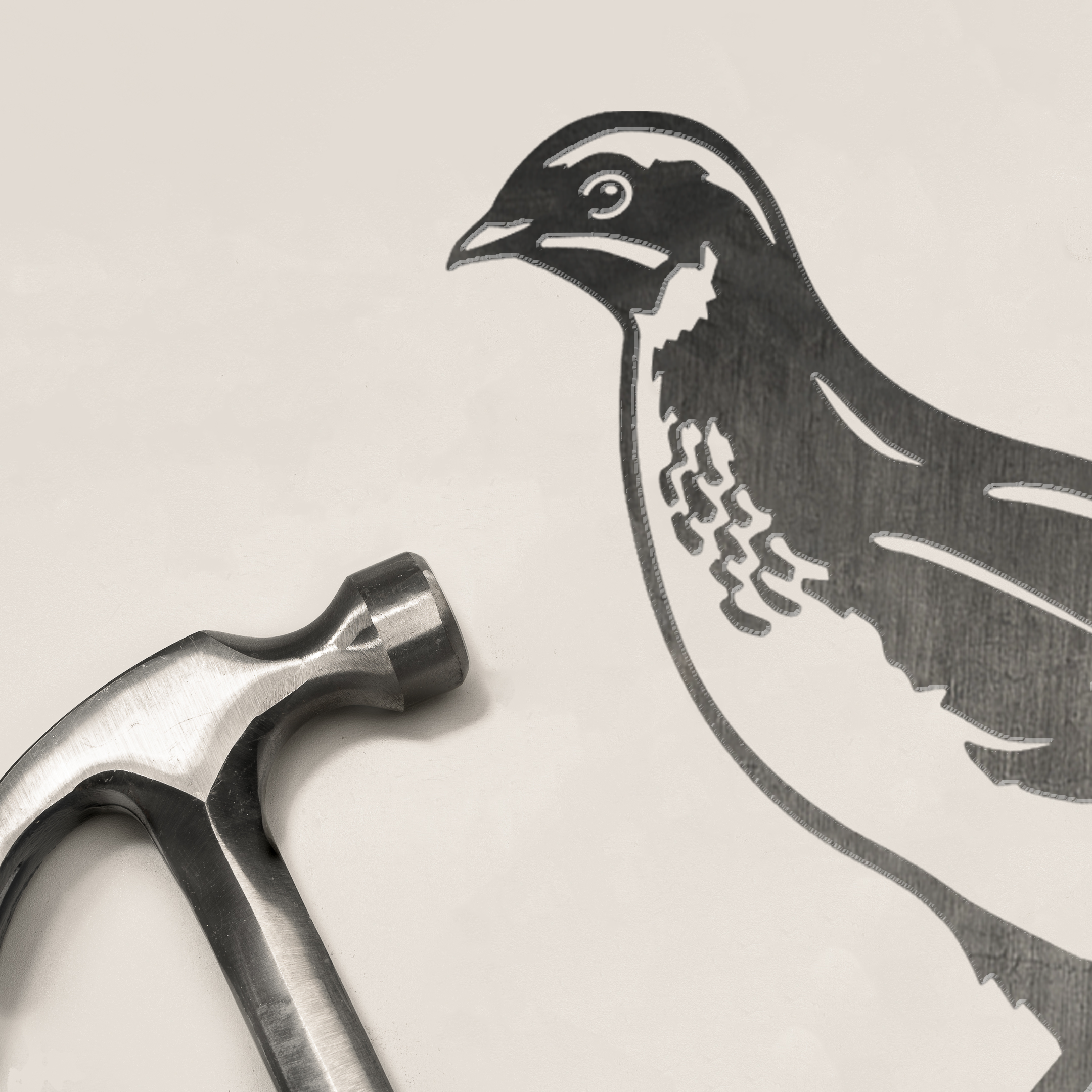 A metal hammer rests on a white surface beside a black outline drawing of a Common Quail by Metalbird UK, creating an inspiring silhouette ideal for corten steel yard art designs.