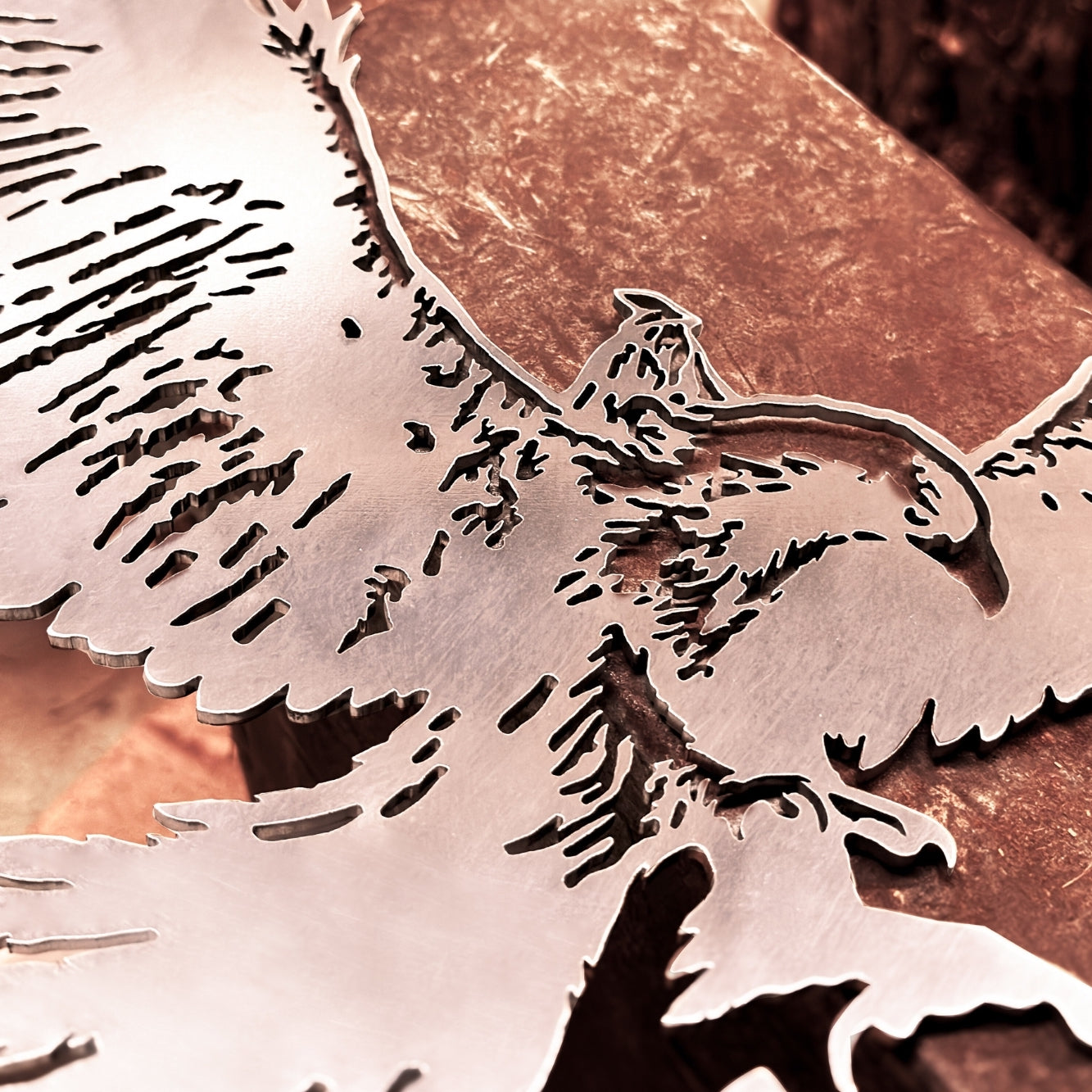 A close-up of Metalbird UK's GANDALF™ ON GWAIHIR™, a premium corten steel sheet sculpture intricately cut to depict Gandalf on Gwaihir, displayed on a copper-toned textured surface.