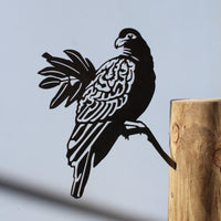 The Manumea by Metalbird UK - CC is a premium black corten steel bird silhouette attached to a wooden post, casting a striking shadow against a light gray background—ideal as unique yard art.