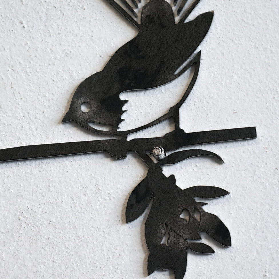 Metalbird UK’s Metalbird Seconds - Robin Pair features two birds perched on a branch with leaves and flowers—an ideal choice for unique metal bird ornaments or discounted garden decor, mounted on any textured wall.