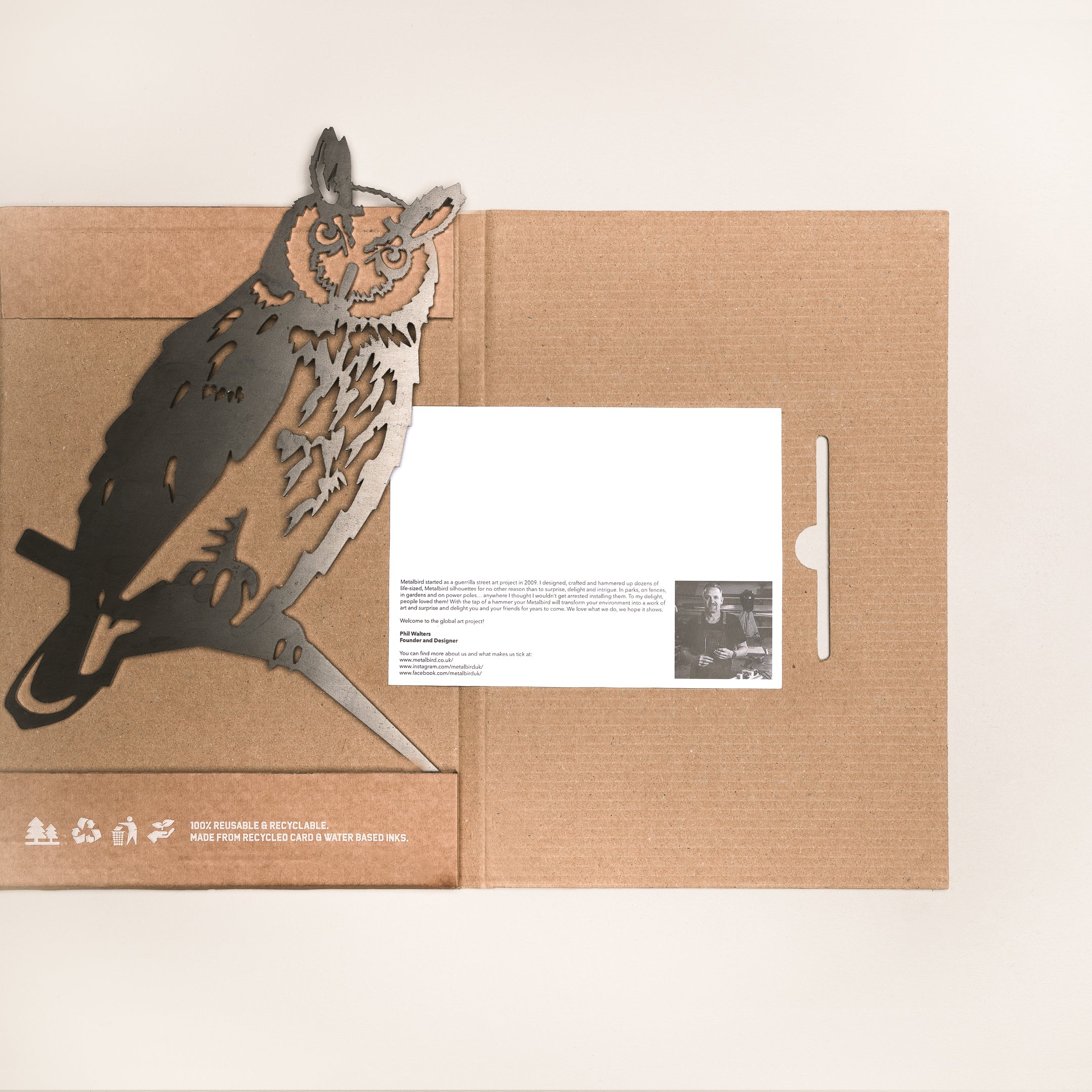The Long-eared Owl by Metalbird UK is a brown cardboard folder with a cut-out corten steel owl on a branch, partially open to show a white info card with a small photo and text—a unique gift for garden art lovers.