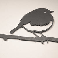 The Metalbird UK Robin features a corten steel silhouette of a robin perched on a branch, cut from a flat sheet. This simple, stylized profile makes an ideal metal gift for nature lovers.
