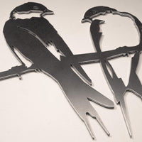 A close-up of Metalbird UK's "Pair of Swallows" wall art shows two stylized swallows perched on a branch, cut from one corten steel sheet—perfect as unique garden decor or a thoughtful gift.