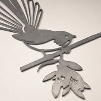The Metalbird UK Fantail (Piwakawaka) is a corten steel cutout of a bird with a fanned tail on a leafy branch—an elegant garden art piece and perfect gift for nature lovers.