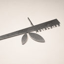 The Metalbird UK Stick Feeder is a metallic ruler-shaped object with a central stem and two oval forms, featuring small metal tabs along one edge—an eye-catching piece for your garden.
