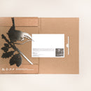 The Wren by Metalbird UK is a metal bird and branch silhouette, packaged in a brown cardboard holder beside an info card with text and a black-and-white photo. Ideal as a gift or yard art, it’s shown against a plain light background.