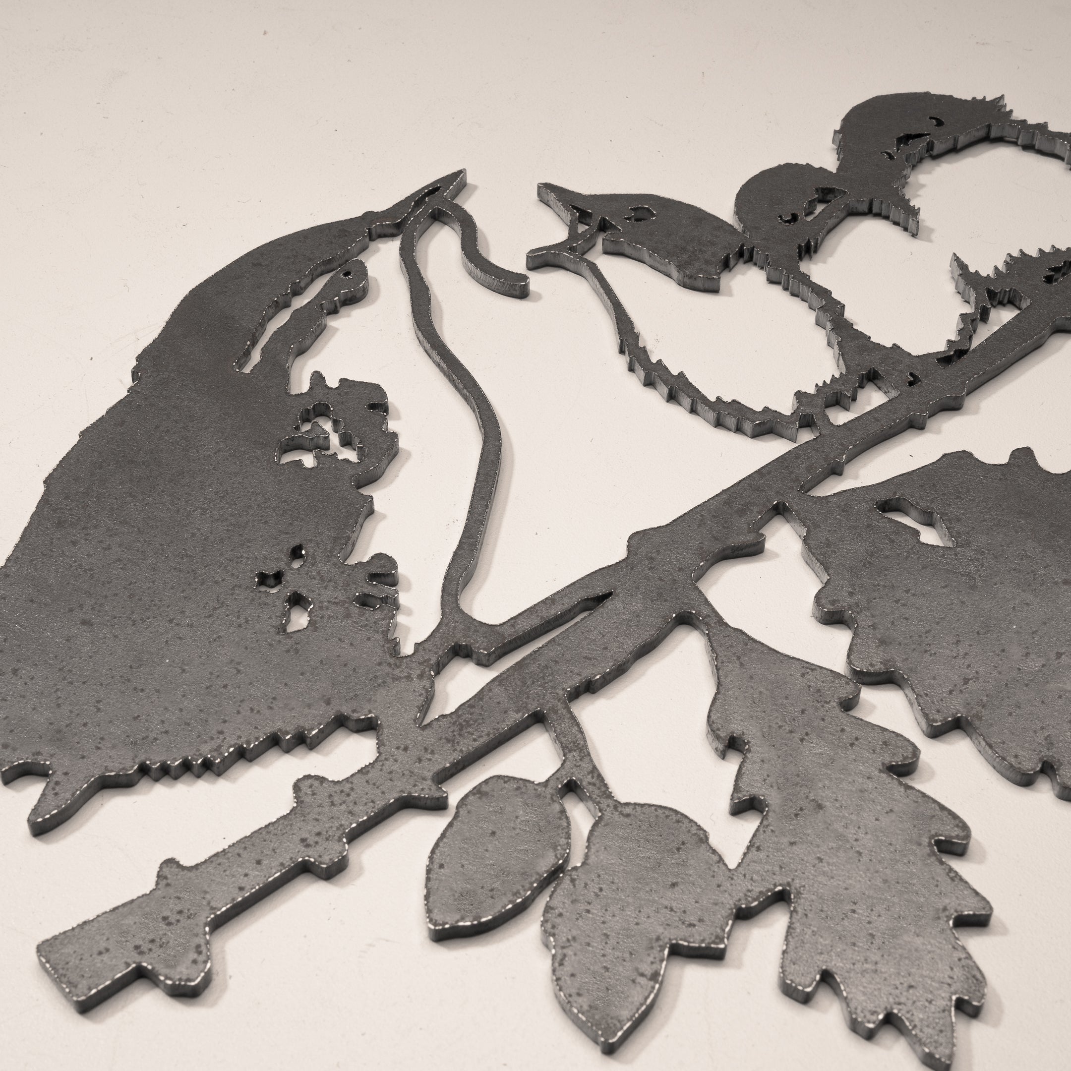 The Metalbird UK "Wren and Chicks" is a stunning metal silhouette artwork of wrens on a branch—ideal for unique yard decor or as a thoughtful gift.