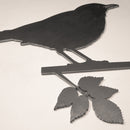 The Blackbird by Metalbird UK is a corten steel silhouette of a bird on a leafy branch, designed to mount on any light wall—a striking yard art piece for your outdoor space.