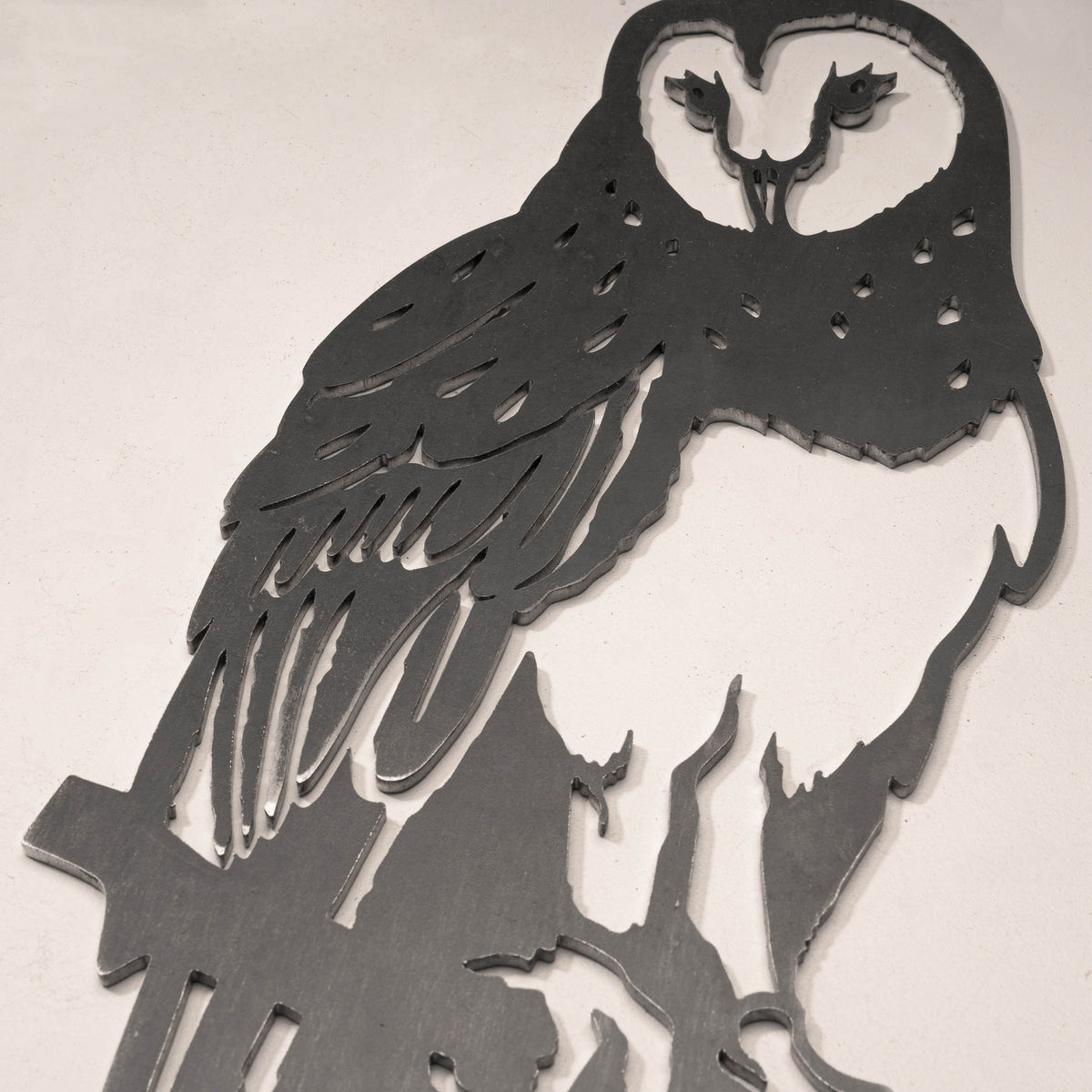 Close-up of the Barn Owl steel silhouette showing the face and feather cutouts.