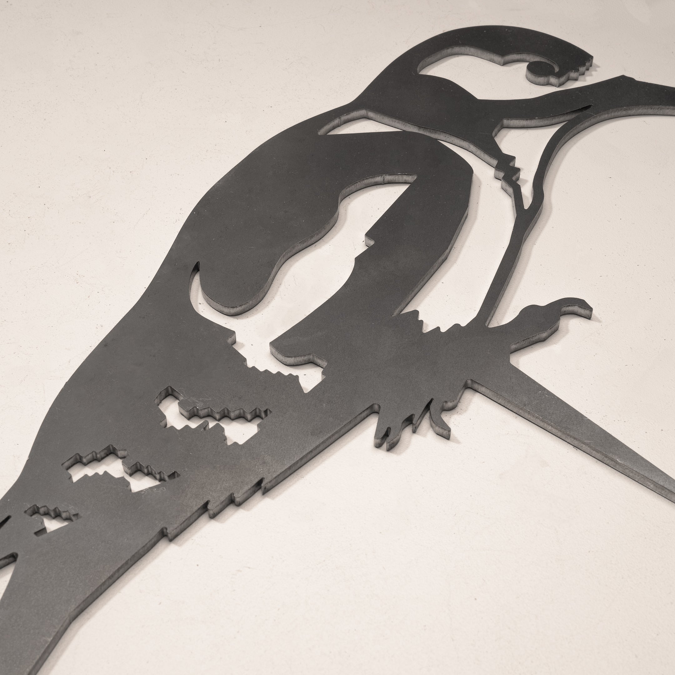 The Great Spotted Woodpecker by Metalbird UK is a corten steel wall art of a woodpecker on a branch, shown on a light background—ideal as unique yard art or a thoughtful gift.