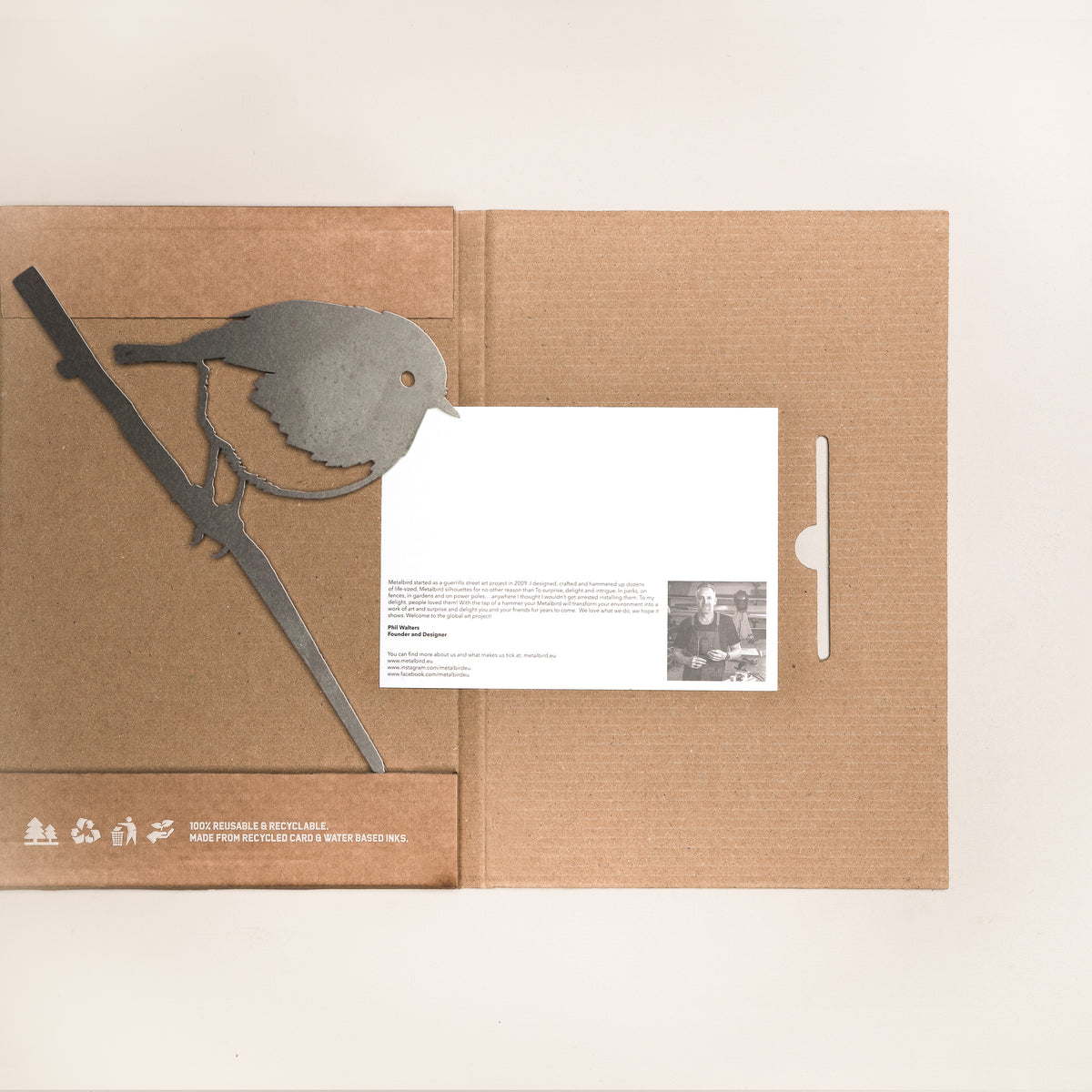 Robin steel silhouette laid across its open cardboard gift packaging with an information card.
