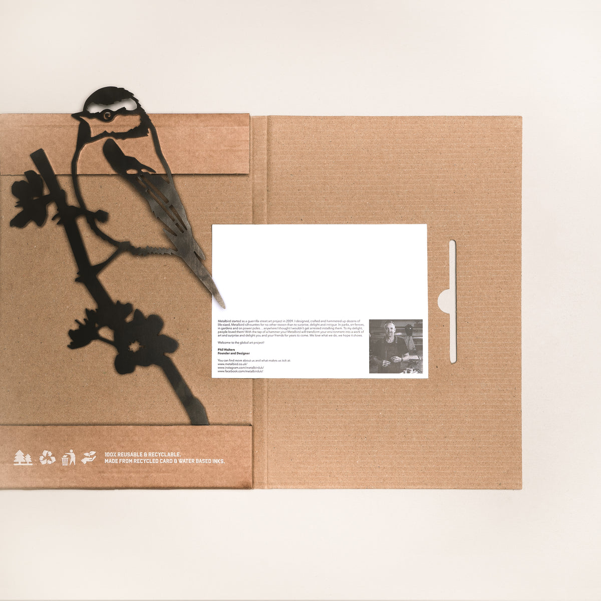 Blue Tit steel silhouette laid across open cardboard packaging with an information card.