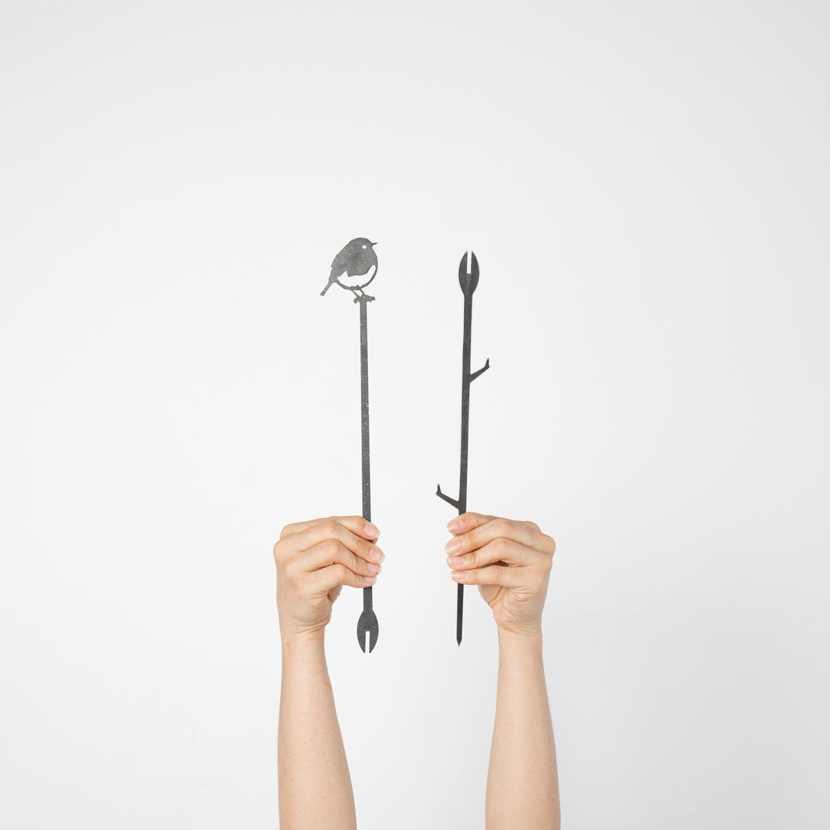 Hands holding the two separate sections of the Robin Plant Stake before assembly.