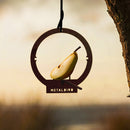 The Metalbird UK Hanging Feeder is a unique round metal bird feeder that holds a sliced pear. Perfect as garden art or a thoughtful gift, it hangs from a tree branch with "METALBIRD" cut out at the base.