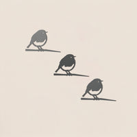 The Baby Bird Bundle - Robin Trio by Metalbird UK features three minimalist black metal robin silhouettes perched on branches—ideal as striking yard art or a thoughtful gift.
